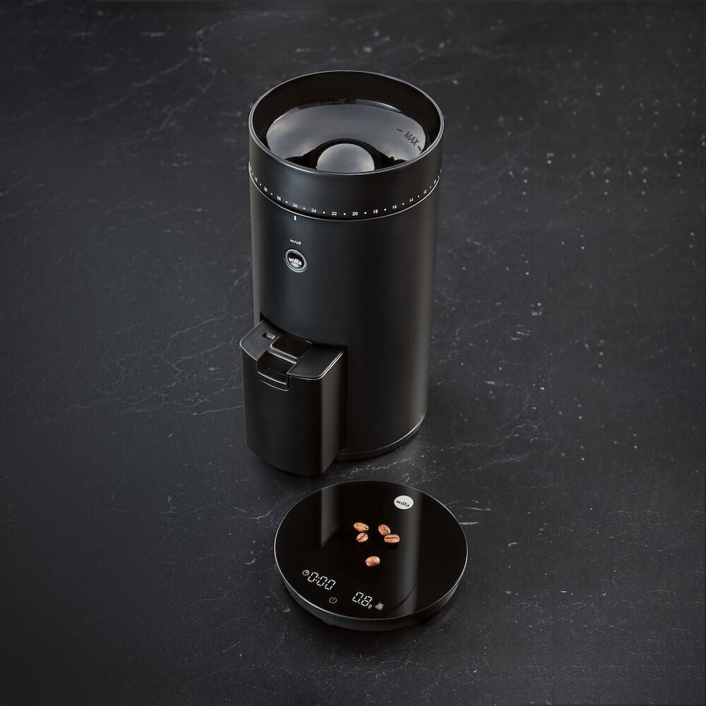 Perfectly Brewed Coffee - A close-up of freshly brewed coffee in a cup with the Wilfa coffee maker in the background. black